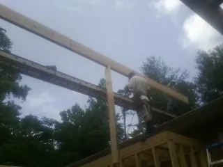 Carpenter setting a ridge beam over a new addition frame — Ice Dam Removal by Roofing Brothers in Elkins Park