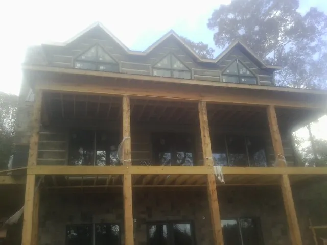 Dormers and porch framing on a large log home under construction — Roof Coating work by our crew in Elkins Park